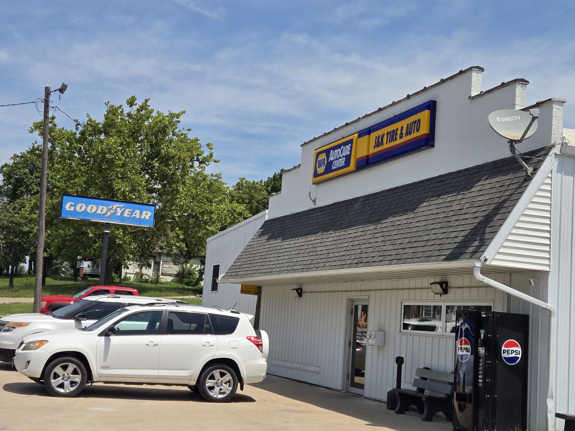 The white J&K Tire & Auto shop building on N Green St with its sign over the door, the Goodyear pole sign and customer cars parked out front